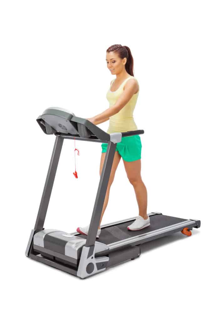Young woman uses treadmill.